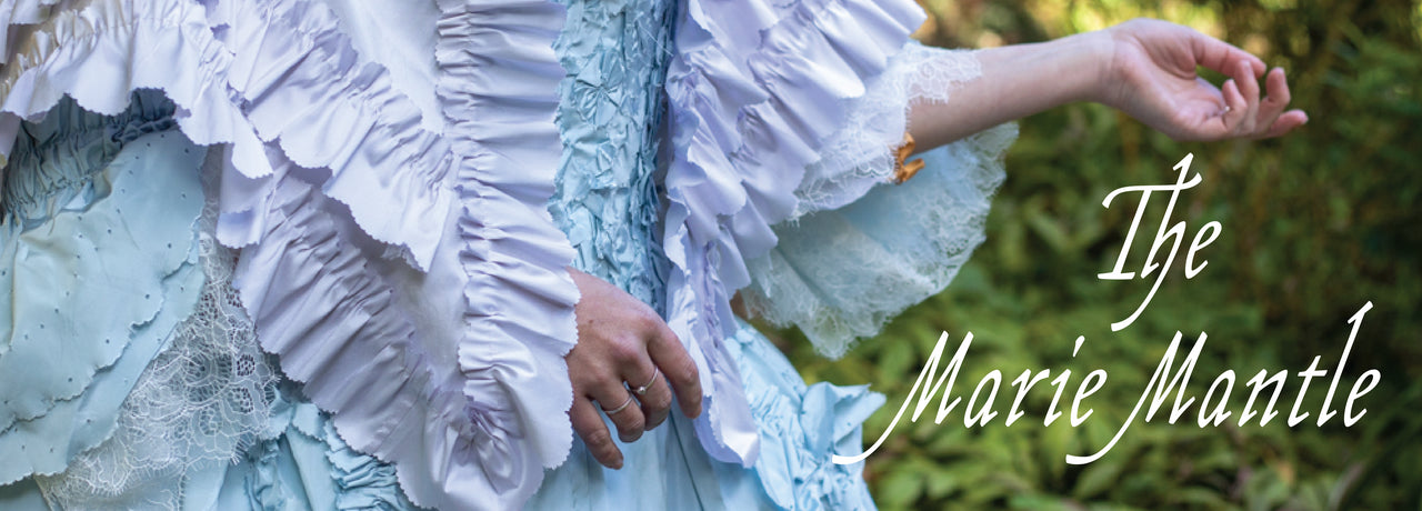 Banner reads 'The Marie Mantle' over a detail of a woman wearing a ruffled lilac silk mantle